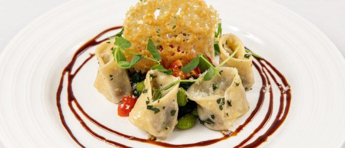 Braised beef tortellini with spinach, a tomato and basil sauce, balsamic reduction and a parmesan cr